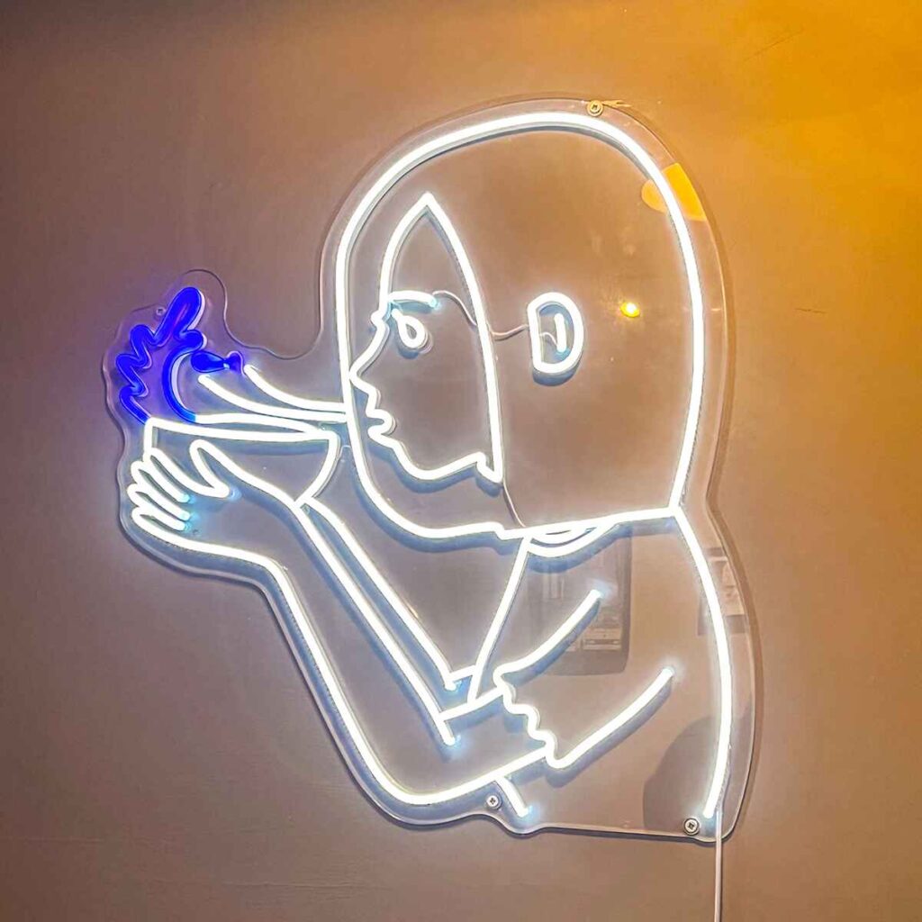 Fluorescent logo of girl blowing a bowl in Blowwater Cafe Kings heath