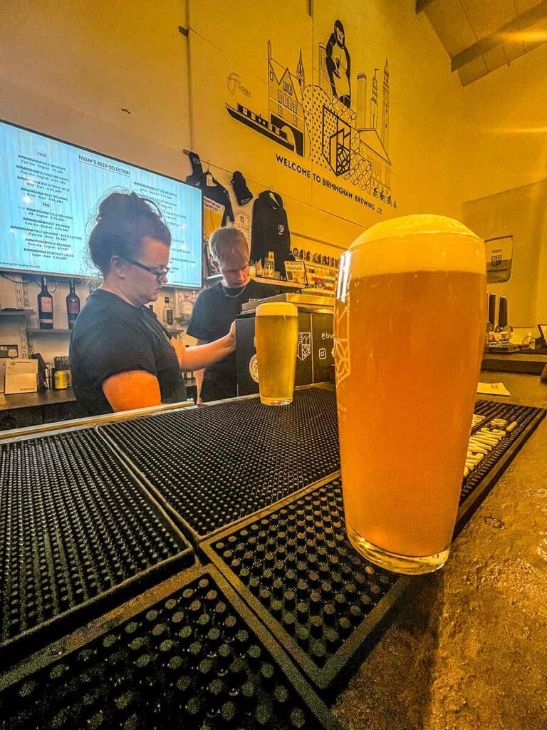 A pint of beer resting on a bar