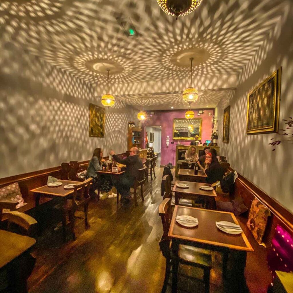 Ornate Arabic light shades dapple patterns on the ceiling of restaurant Byzantium in Kings Heath