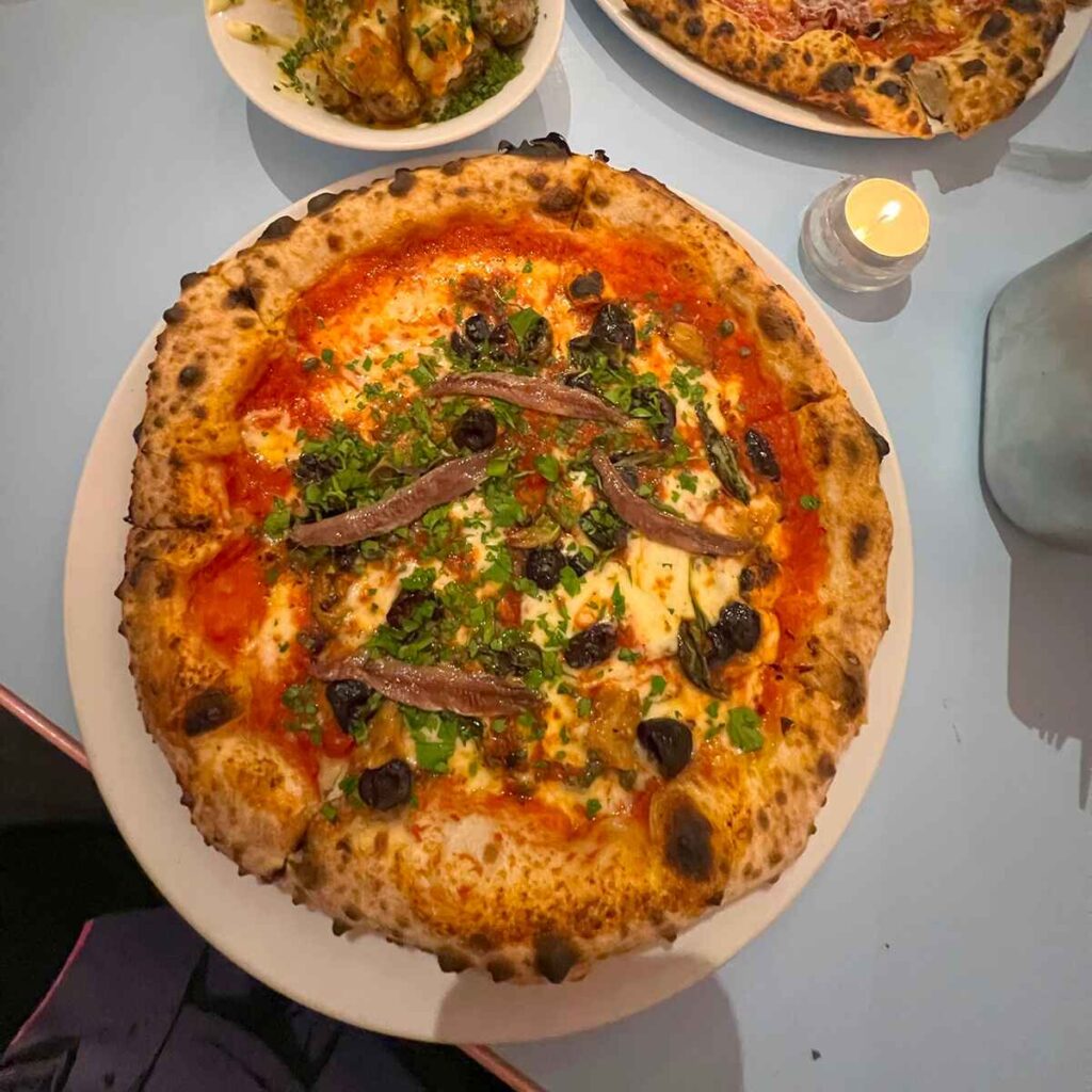 A wood fired pizza with anchovies and olives