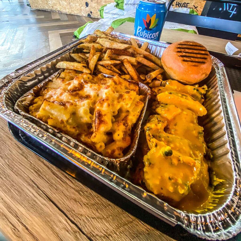 A tray of mac and cheese, chicken, fries and brioche bun