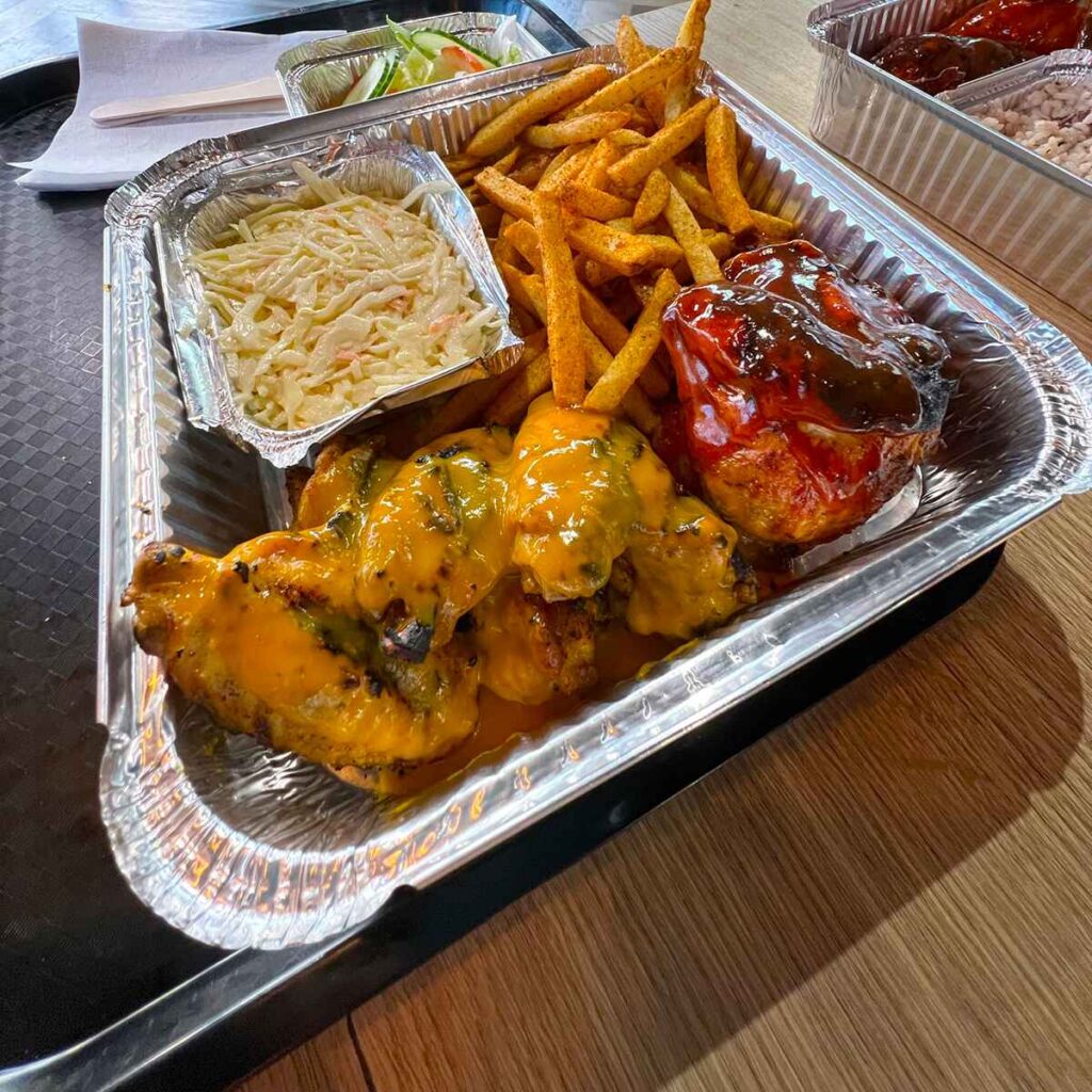 A tray of fried chicken, fries and coleslaw