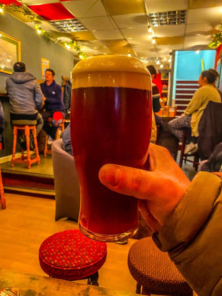 A person holds a pint of beer at Redbeerd