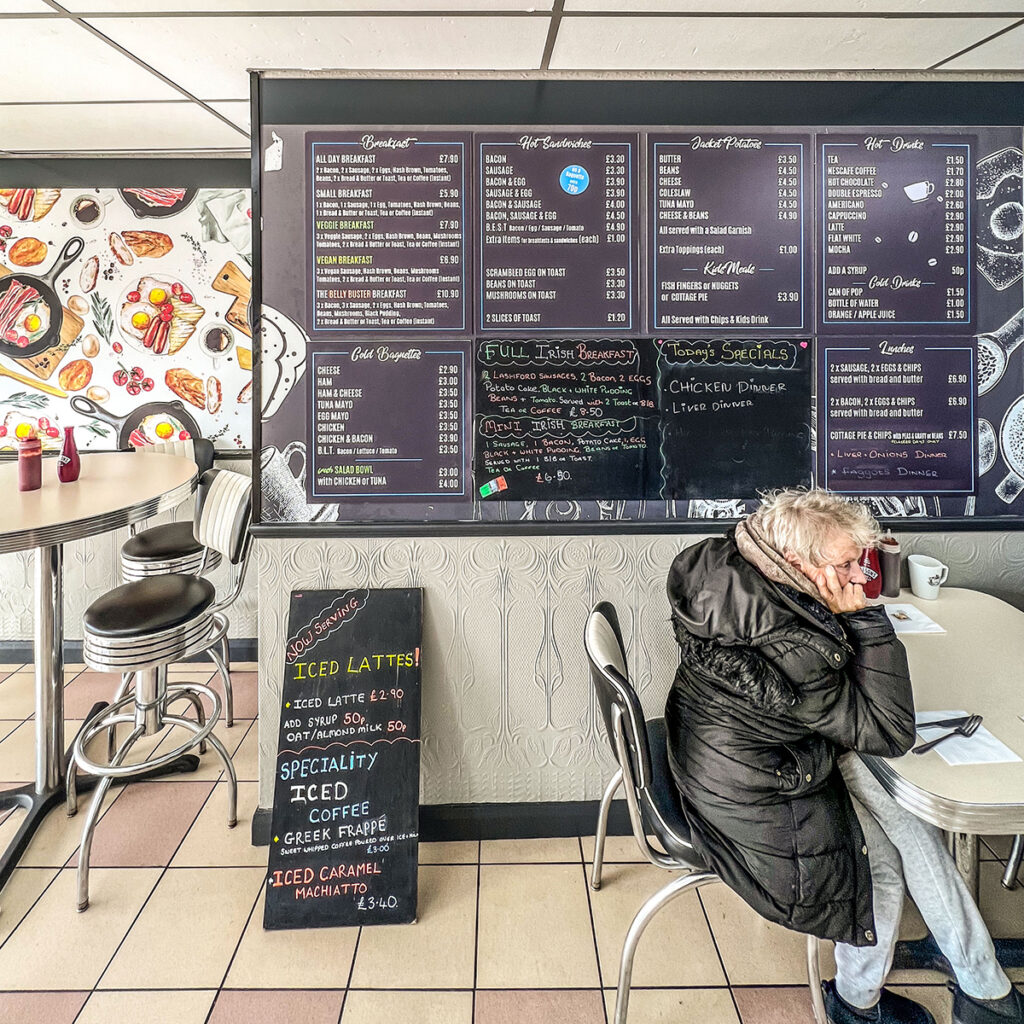 An interior shot of Broad Lane Cafe. A person is sat on their own
