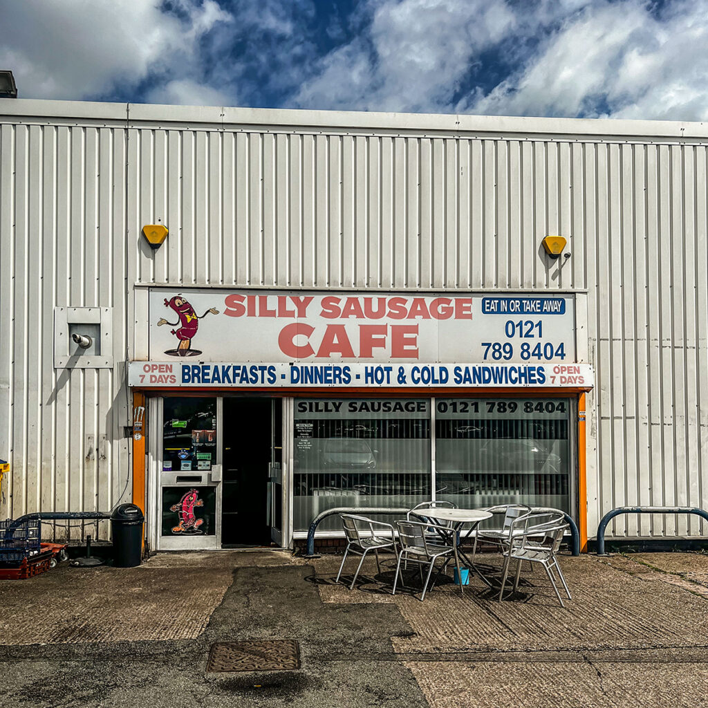 The front of Silly Sausage cafe, with empty table and chairs outside

