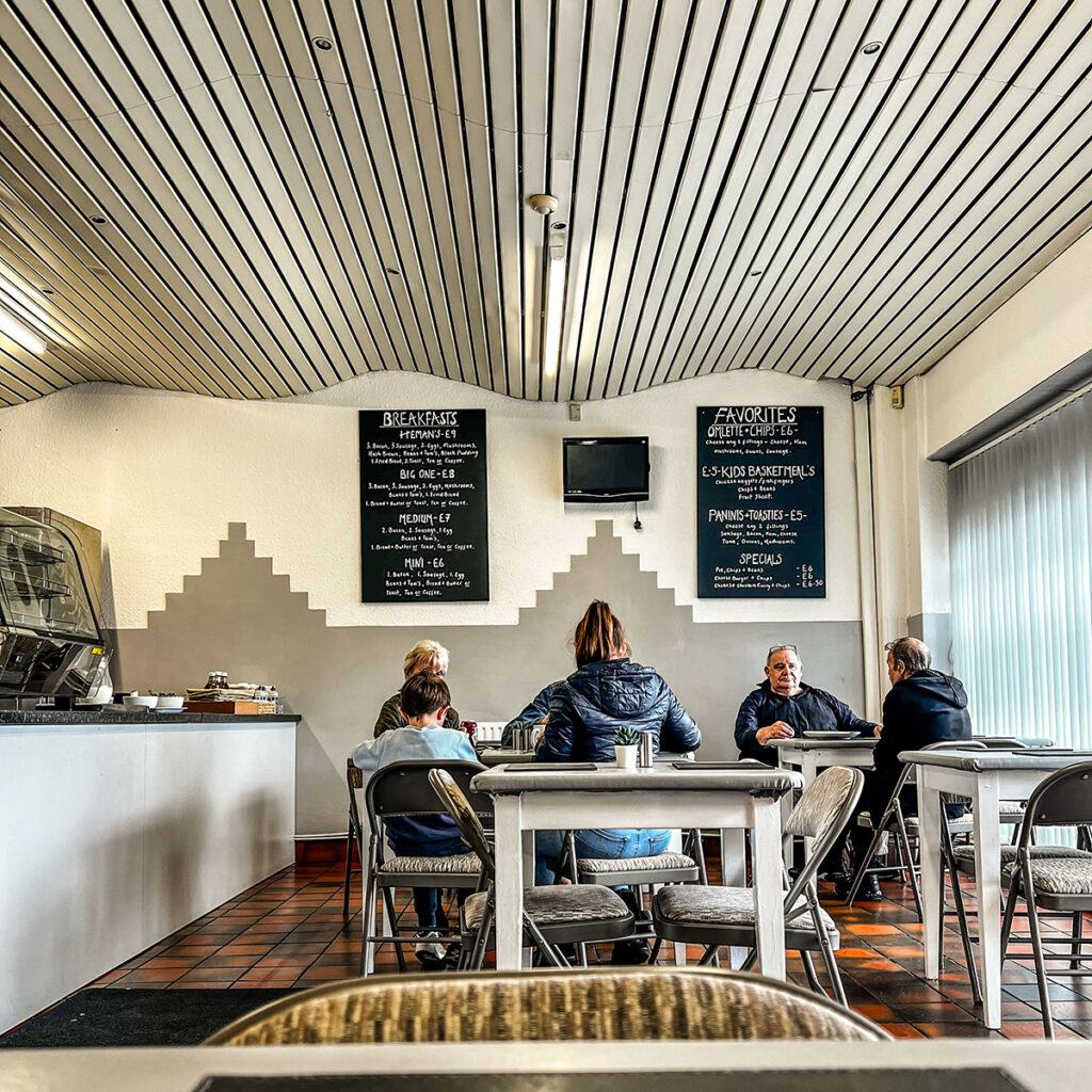 An interior shot of Silly Sausage Cafe. There are four people sat having breakfast.

