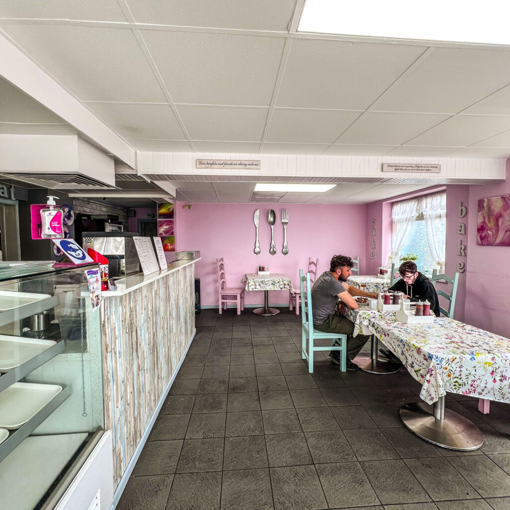 An interior shot of Janes cafe, with two people sat eating
